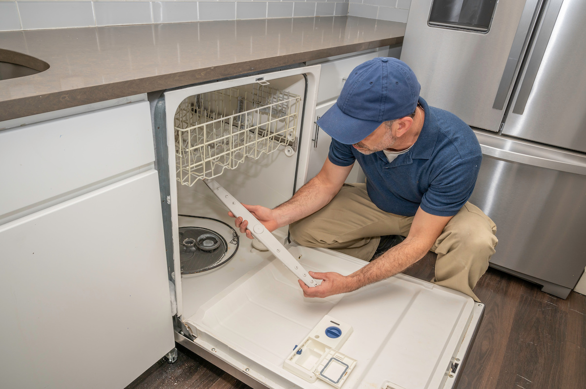 Appliance repairman working on a broken dishwasher